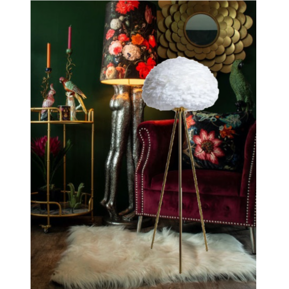 Decorative lamp with a white shade on a gold stand in a stylish room.