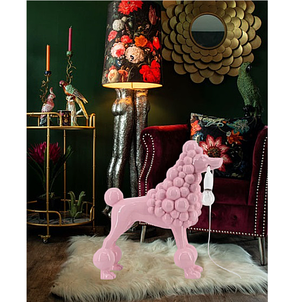 Pink poodle-shaped lamp in a stylish room with floral accents and a bar cart.